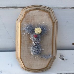 Crocheted tiny mouse on a wood plaque